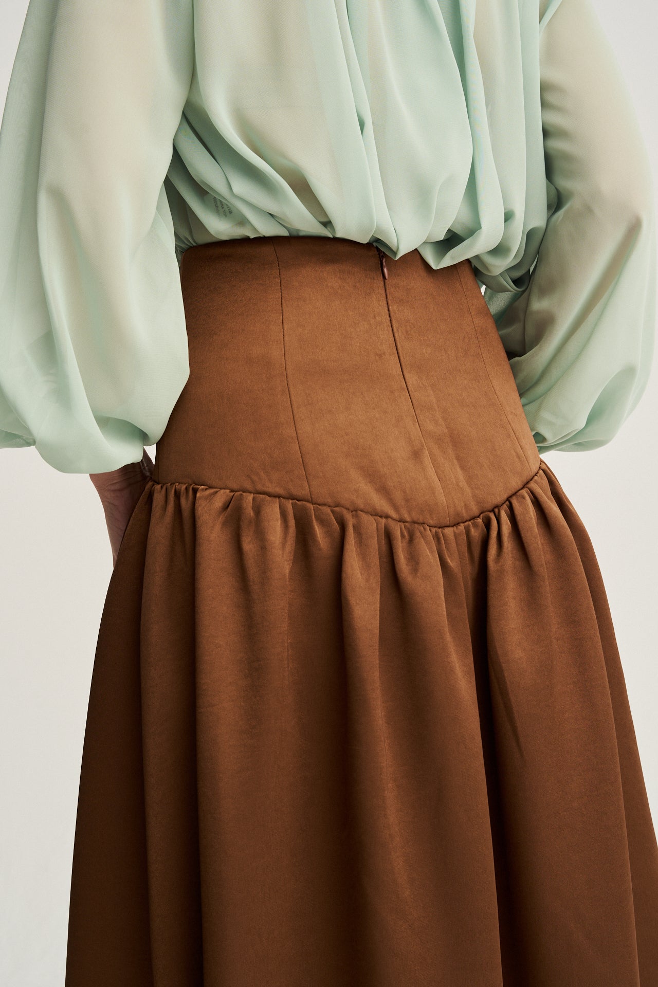 Falda midi sofisticada con tejido tafetán en tono chocolate, ideal para combinar con blusas románticas o tops minimalistas.