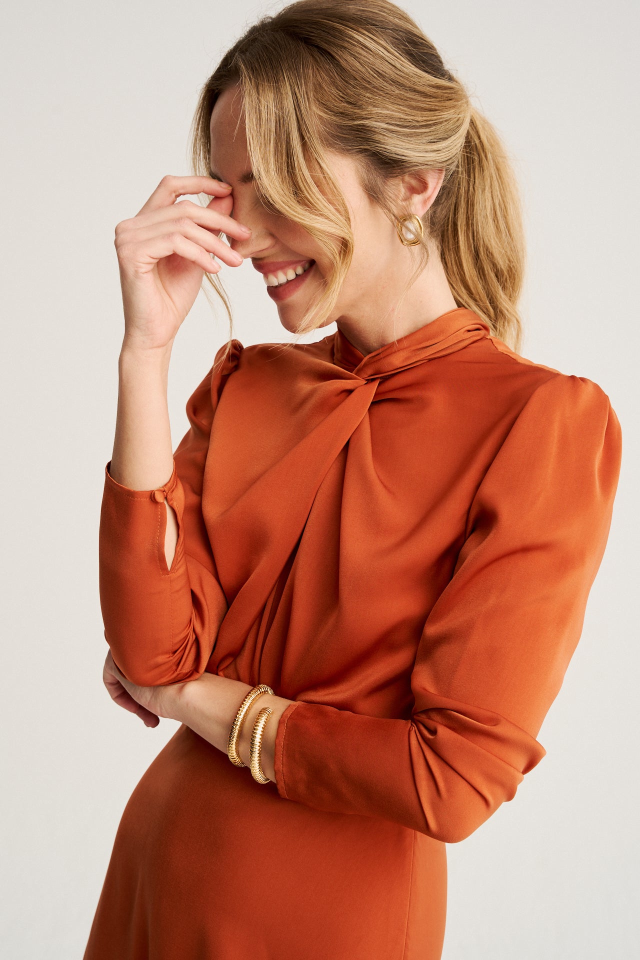 Vestido de color teja naranja con cuello fruncido, lazada a la espalda y detalles de botones forrados cosidos a mano.