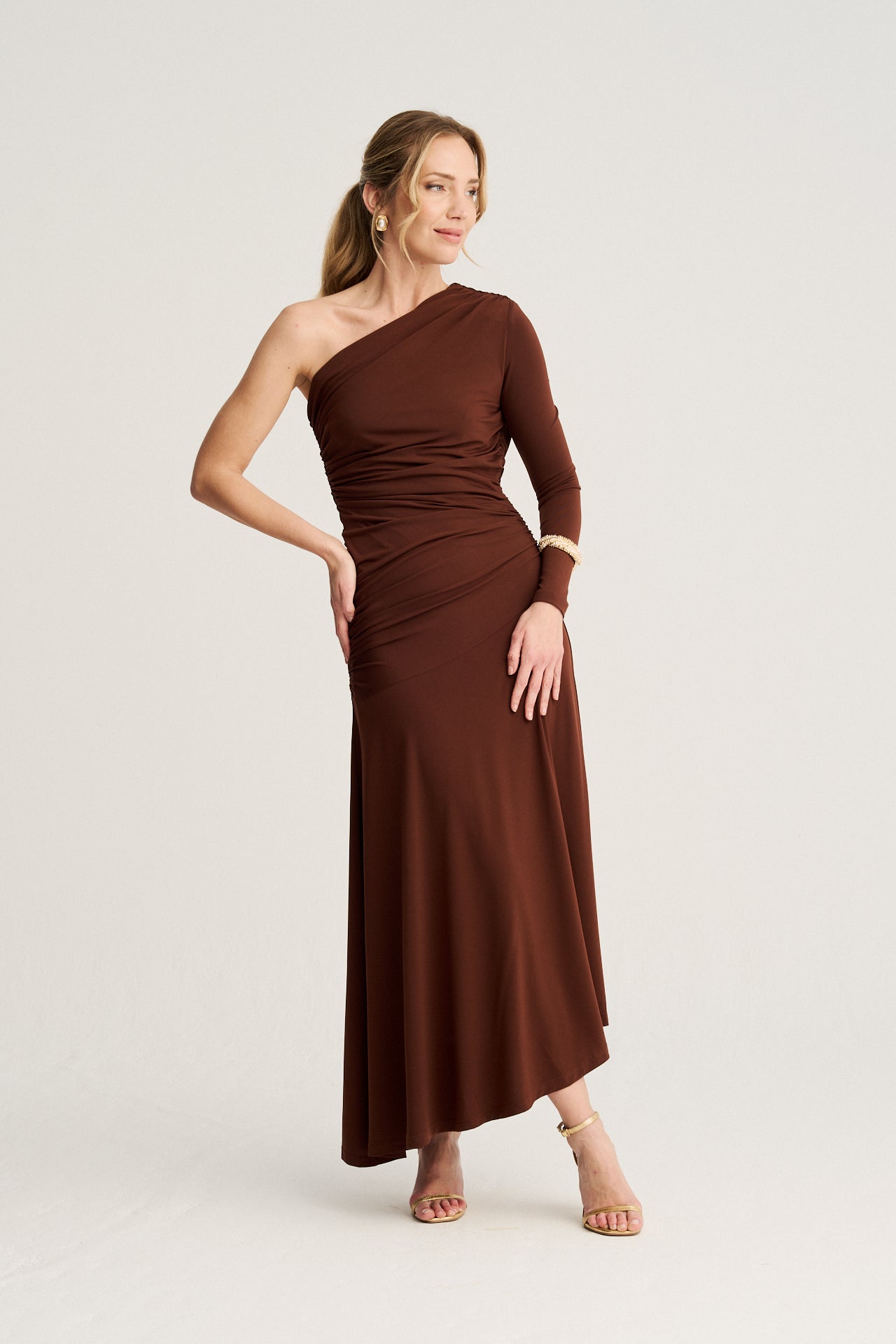 Vestido midi marrón chocolate de punto de seda con escote y bajo asimétrico, un diseño fluido que realza la silueta con elegancia.