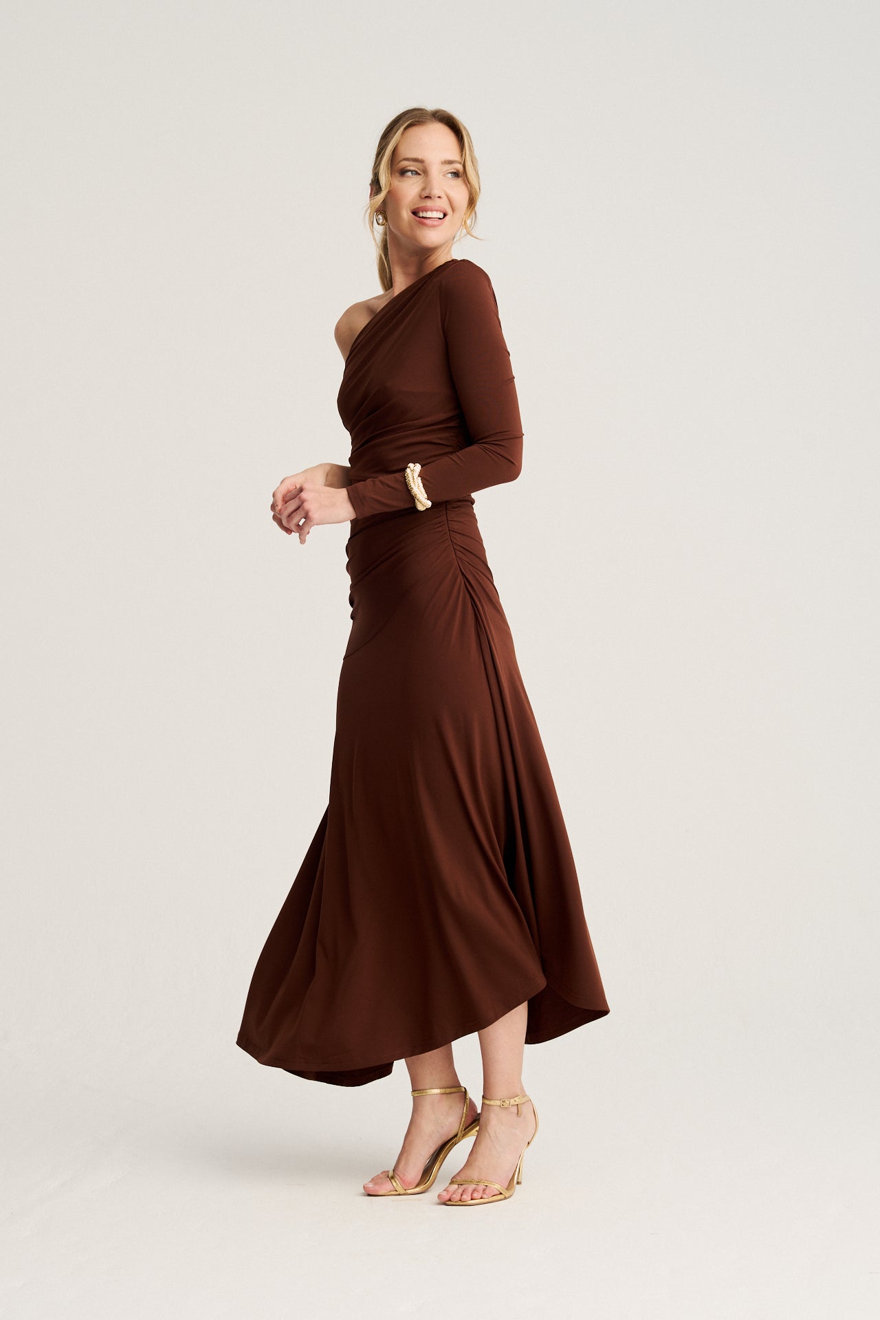 Vestido Matis en marrón chocolate con escote asimétrico y corte envolvente en la falda, ideal para bodas de otoño e invierno con un aire sofisticado.