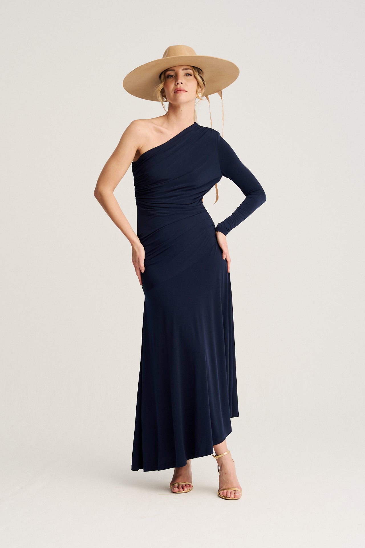 Vestido de invitada en azul noche con escote asimétrico y fruncido en la cintura, una opción elegante y favorecedora para bodas y eventos.